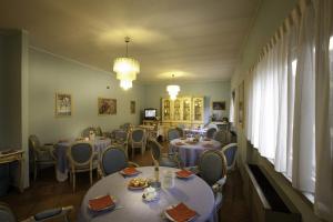 a dining room with tables and chairs and a room with at Hotel Nastro Azzurro in Monguzzo 