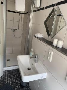 a white bathroom with a sink and a shower at Wein- und Sektgut Markus Hensler in Briedel