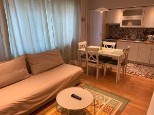 sala de estar con sofá, mesa y cocina en IGI WHITE FLAT with free private parking, en Cluj-Napoca