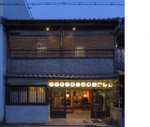 una vista exterior de un edificio por la noche en ダース旅館＆カフェ（Dozen-Ryokan＆Cafe） en Nishi-kujō-Toriiguchichō