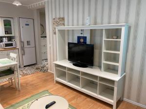 een woonkamer met een tv op een wit entertainmentcentrum bij IGI WHITE FLAT with free private parking in Cluj-Napoca