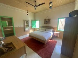 1 dormitorio con 1 cama y lavamanos. en Al Bait resort with private swimming pools -HRS stables, en Al Ḩamrānīyah