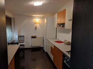 a kitchen with white walls and wooden cabinets and a table at Dorobanți Loft in Bucharest