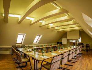 una lunga sala da pranzo con tavoli e sedie lunghi di Hotel Brixen a Havlíčkŭv Brod