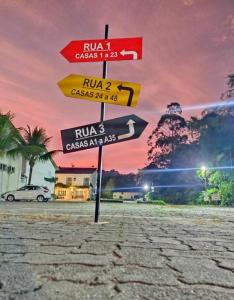 a group of signs on a pole in a street at Casa incrível em Condomínio , em juquehy 44 in Juquei