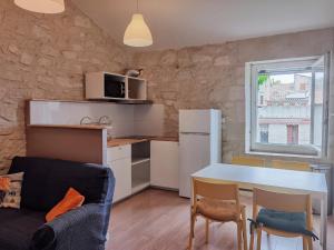 a kitchen and living room with a table and chairs at Chez Waucquier in Beaucaire