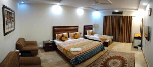 ein Schlafzimmer mit einem Bett und einem Stuhl in einem Zimmer in der Unterkunft Seaview Lodge Guest House in Karatschi