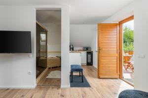 uma sala de estar com uma porta de correr e uma televisão em Kapocs Apartmanház em Borgáta