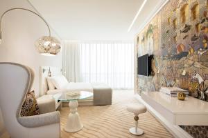 a living room with a bed and a couch at Mondrian Doha in Doha