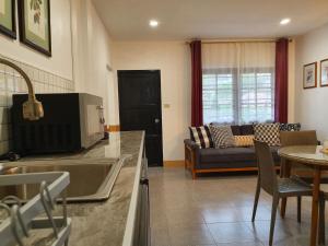 cocina y sala de estar con sofá en Holiday Village And Natural Garden Resort, en Karon Beach