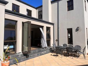 a patio with a table and chairs next to a building at Jambase Seaside House in Big Bay