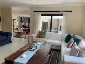 a living room with a white couch and a table at Jambase Seaside House in Big Bay