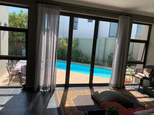 a living room with a view of a swimming pool at Jambase Seaside House in Big Bay