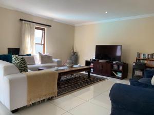 a living room with a couch and a tv at Jambase Seaside House in Big Bay