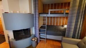 een slaapkamer met een stapelbed en een open haard bij Rukankieppi in Ruka