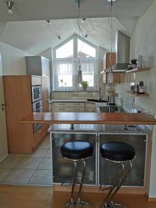 una cocina con 2 taburetes de barra en Apartment an der Lindach, en Kirchheim unter Teck