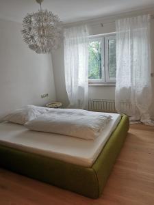 a bed in a bedroom with a chandelier at Apartment an der Lindach in Kirchheim unter Teck