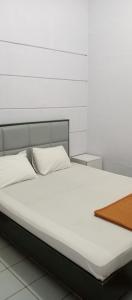 un letto con lenzuola bianche e un vassoio di legno di HOTEL MAYA a Tegal