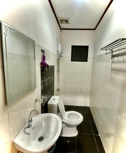 uma casa de banho com um WC branco e um lavatório. em Sophias Beach Guest House em El Nido
