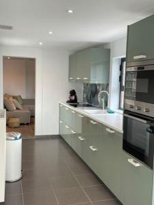 een keuken met een wastafel en een fornuis top oven bij Cosy flat for 4 p. with garden in Tremelo 