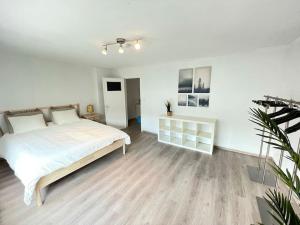 een witte slaapkamer met een groot bed in een kamer bij Cosy flat for 4 p. with garden in Tremelo 