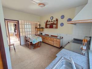 eine Küche mit Spüle und Tisch in der Unterkunft Outes centro in Sierra de Outes