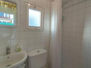 ein Badezimmer mit Toilette, Waschbecken und Fenster in der Unterkunft Outes centro in Sierra de Outes