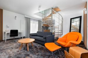 sala de estar con sofá y sillas de color naranja en Luxury Apartment Pogorzelica, en Pogorzelica