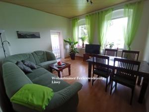ein Wohnzimmer mit einem grünen Sofa und einem Tisch in der Unterkunft Ferienwohnungen Familie Winter in Dohna