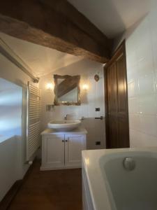 bagno con vasca, lavandino e specchio di Ponte del Mera Attic a Chiavenna