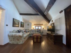 sala de estar con sofá y TV en Ponte del Mera Attic en Chiavenna