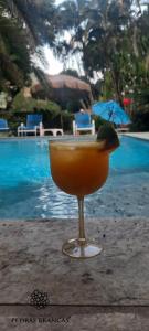 una bebida sentada en una mesa junto a una piscina en Pousada Pedras Brancas, en Niterói