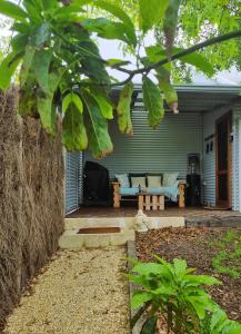 a blue house with a couch on a patio at Brushwood Studio in Denmark