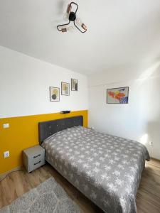 a bedroom with a bed and a yellow wall at Cozy Apartment - near Airport and Palas Mall in Iaşi