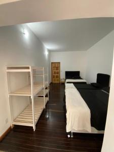 1 dormitorio con 2 camas y estante para libros en Hotel fazenda Pousada Fazendinha beach club arraial do cabo en Arraial do Cabo