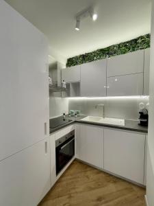a white kitchen with white cabinets and a sink at ALBARIA ROOMS-APARTMENTS in Marsala