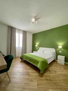 Un dormitorio con una cama grande con una pared verde. en ALBARIA ROOMS-APARTMENTS, en Marsala