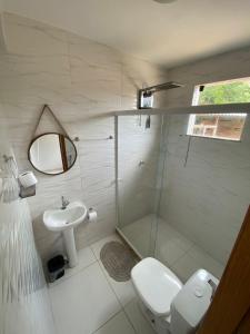uma casa de banho com um chuveiro, um WC e um lavatório. em Hotel fazenda Pousada Fazendinha beach club arraial do cabo em Arraial do Cabo