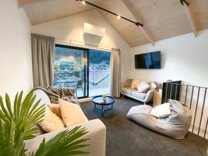 una sala de estar con 2 sofás y una ventana grande en Modern 2-bedroom Apartment 7-mins walk to Queenstown, en Queenstown