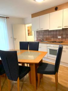 Una cocina con una mesa y sillas de madera. en Ferienwohnung in Weissach im Tal, en Weissach Im Tal