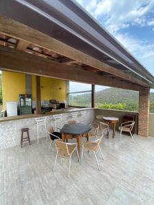 eine Terrasse mit Tischen, Stühlen und einer Theke in der Unterkunft Hotel fazenda Pousada Fazendinha beach club arraial do cabo in Arraial do Cabo