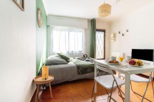 a bedroom with a bed and a desk and a table at Appart'Hotel NuiteeJour Versailles Saint Cyr l'Ecole in Saint-Cyr-lʼÉcole