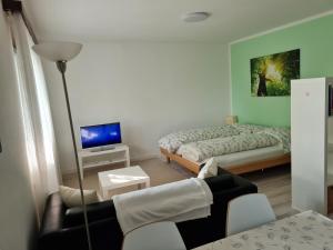 mały pokój z łóżkiem i kanapą w obiekcie Gabi's Wolfühloase w mieście Balerna