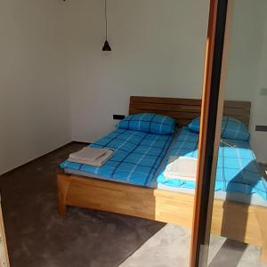 a bedroom with a bed with blue pillows and a mirror at Apartmán 107 Ovruč in Štrbské Pleso