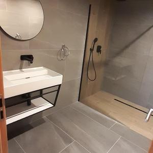 a bathroom with a shower and a sink and a mirror at Apartmán 107 Ovruč in Štrbské Pleso