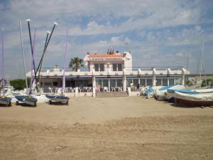 un edificio en la playa con barcos delante en Torredembarra cosy, well equipped house, 5 min. from the beach en Torredembarra