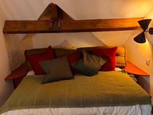 una camera da letto con un letto con cuscini rossi e verdi di La passerelle, duplex atypique de charme a Wimereux