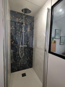una doccia in bagno con carta da parati floreale di La passerelle, duplex atypique de charme a Wimereux