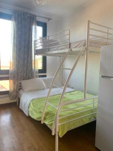 a bedroom with two bunk beds and a refrigerator at BLUE HOUSE in Paliouri