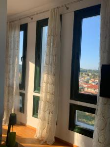 a room with three windows with white curtains at BLUE HOUSE in Paliouri